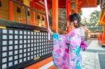 Women In Traditional Japanese Kimonos At Fushimi Inari Shrine In Kyoto, Japan Stock Photo