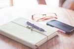 Notebook And Smartphone On Wooden Table Stock Photo