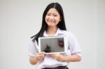 Portrait Of Thai High School Student Uniform Beautiful Girl Using Her Tablet Stock Photo