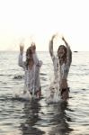 Two Women In The Water Splashing And Having Fun Stock Photo