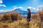 Beautiful Girl Standing At Kawaguchiko Lake With View Of Fuji Mountain, Autumn In Japan Stock Photo