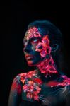 Beautiful Flowers In Uv Light On A Young Girl Face And Body Stock Photo