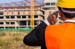 Close Up Young Engineer Wearing A Orange Shirt Stands Talking On Stock Photo