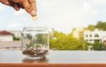 Close Up Of Glass Bottle Stacking Silver Coins Stock Photo