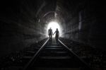 Couple Walking Together Through A Railway Tunnel Stock Photo