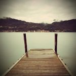 Tranquil Scene Of Old Wooden Pier And Misty Italian Alps Mountai Stock Photo