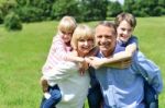 Kids Enjoying Piggy Ride On Parents Back Stock Photo