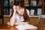 Portrait Of Thai Adult Student University Uniform Beautiful Girl Reading Red Book Stock Photo