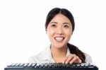 Cheerful Girl Using Computer Keyboard To Type Stock Photo