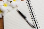 A Pen And Notebook With Flower Stock Photo