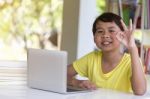 Asian Child Giving Ok Sign Gesture With Laptop Computer I Stock Photo