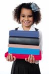 Cute School Girl Carrying Stack Of Books Stock Photo