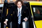 Corporate Guy Getting Out Of A Taxi Cab Stock Photo