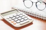 Calculator With Eyeglasses On Wooden Table Stock Photo