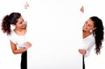 Women Smiling Behind White Board Stock Photo