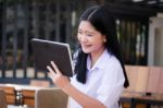 Portrait Of Thai High School Student Uniform Beautiful Girl Using Her Tablet Stock Photo