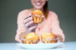 Happy Young Woman Eating Delicious Muffins Stock Photo