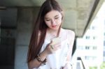 Portrait Of Thai Adult Beautiful Girl Using Her Smart Phone And Smile Stock Photo