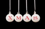 Word Xmas On White Christmas Balls Hanging On Black Background Stock Photo