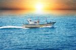 Fishing Boat In Sea At Sunset Stock Photo