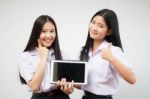 Two Asia Thai High School Student Uniform Best Friends Beautiful Girl Using Her Tablet And Funny Stock Photo