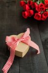 Gift  With A Red  Bow And Bouquet Of Roses Stock Photo