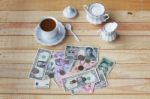 Money On Wooden Panel With Coffee Set Stock Photo