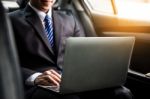 Handsome Young Businessman Using Laptop And Sitting In Back Seat Stock Photo