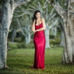 Beautiful Young Woman In The Gardens Wearing A Long Silk Red Dress Stock Photo