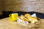 Garlic Bread Served In Basket With Cup Of Coffee On Table Stock Photo