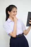 Portrait Of Thai High School Student Uniform Beautiful Girl Using Her Tablet Stock Photo