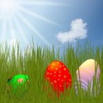 Colorful Easter Eggs Sitting On Grass Field With Blue Sky Backgroun Stock Photo