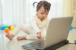 Little Asian Girl Play Laptop In Home Stock Photo