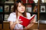 Portrait Of Thai Adult Student University Uniform Beautiful Girl Reading Red Book Stock Photo