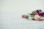 Heap Of Medicine Pills On Cardiogram Grid Paper. Selective Focus Stock Photo