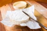 Camembert Cheese Wrapped In Paper With Vintage Knife On Wooden T Stock Photo