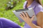 Tablet Computer On Hand Of Beautiful Young Woman In Park Stock Photo