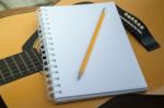 Yellow Acoustic Guitar On Wooden Table Stock Photo