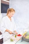 Woman Making Fruit Salad In Kitchen Stock Photo