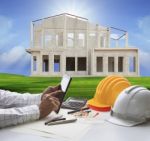 Hand Of Architect Working On Computer Tablet  And House Construction Background Stock Photo