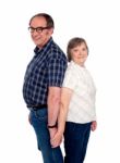 Aged Couple Posing Back To Back Stock Photo