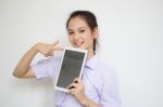 Portrait Of Thai High School Student Uniform Beautiful Girl Using Her Tablet Stock Photo