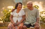 Happy Senior Couple Sitting Outdoors Stock Photo