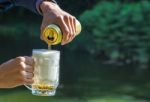 Man Pouring Beer From A Jar Into A Mug Stock Photo