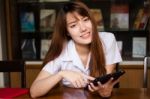 Portrait Of Thai Adult Student University Uniform Beautiful Girl Using Her Tablet Stock Photo