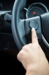 A Woman Hand Pushes The Volume Control Button On A Steering Wheel Stock Photo