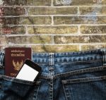 Blue Jeans With Cell Phone And Passport In A Pocket Background Stock Photo