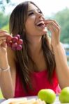 Young Girl Eating Grapes On Romantic Picnic In Countryside Stock Photo