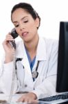 Asian Female Doctor Talking Over Phone Stock Photo