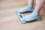 Woman's Legs Standing On The Scales Stock Photo